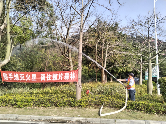 西门保安对停车场周边进行洒水降燥.jpg