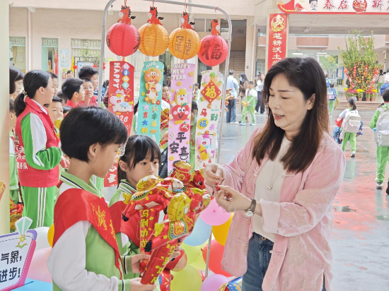 3沙坪三小校长为三小学子送上马年吉祥物挂件，寓意马到成功、前程似锦。.png