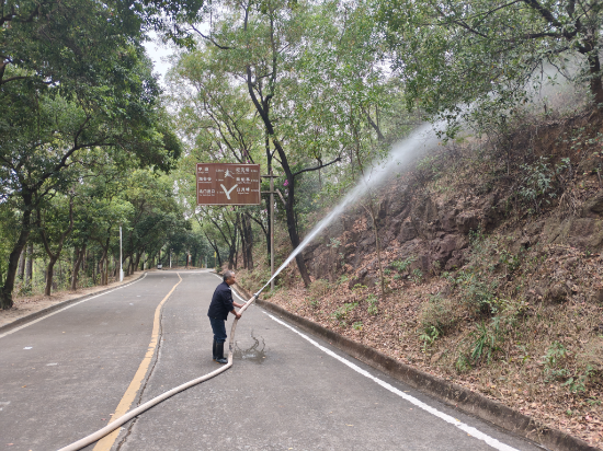 山顶保安对山顶山路边进行洒水降燥.jpg